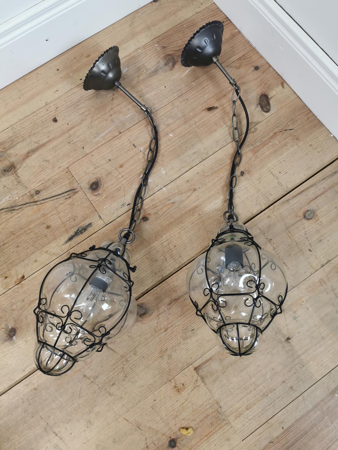 Pair of wrought iron and hand blown glass lanterns.