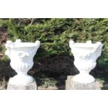 Pair of stone urns with rose and swag decoration.