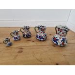 Set of five graduated hand painted stoneware water jugs.