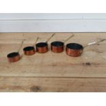 Set of five copper and brass graduated sauce saucepans