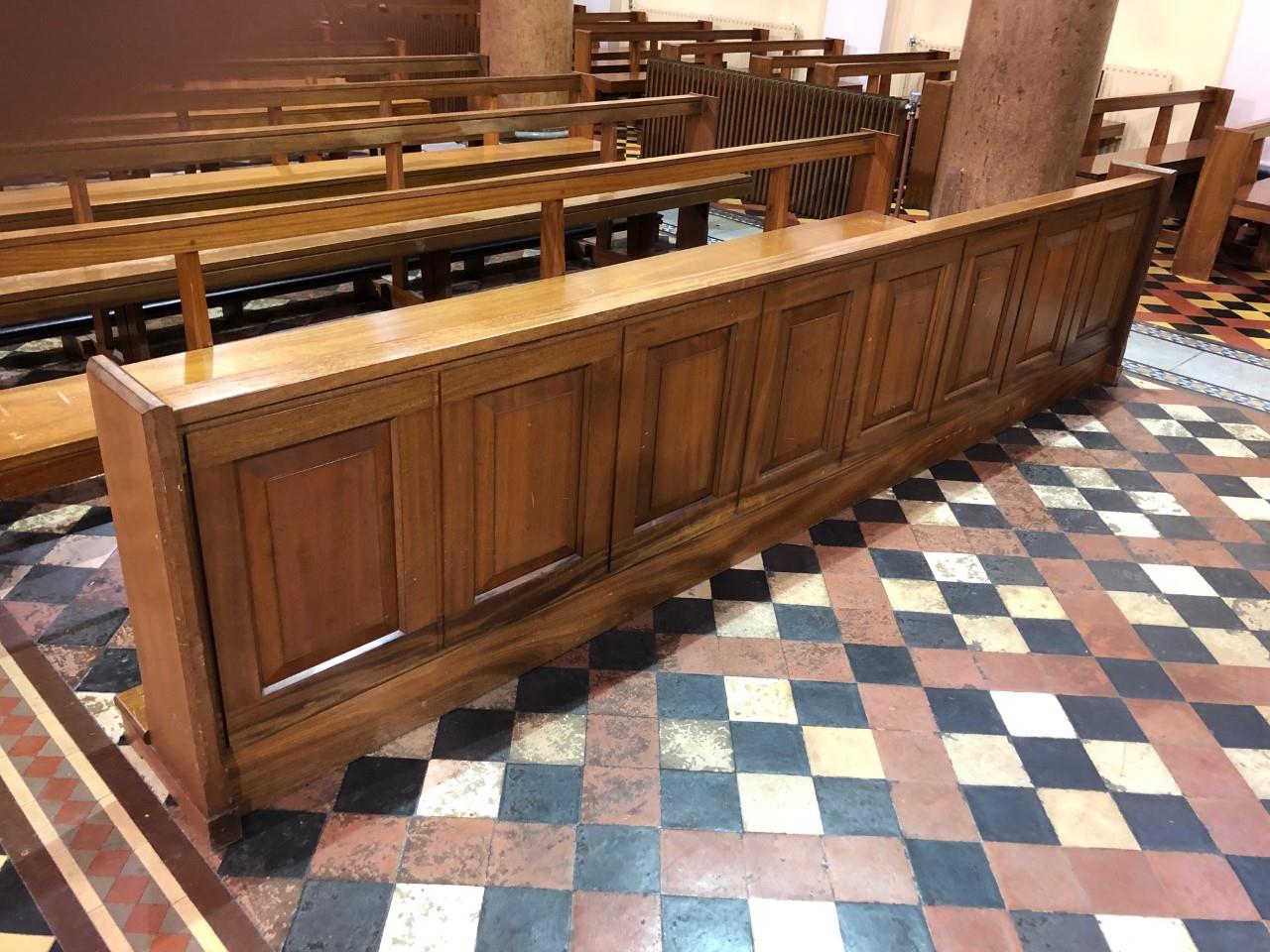 Two pews fronted with mahogany panels.