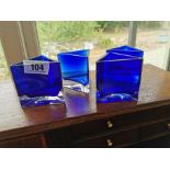 Four modern blue glass Triangular candle holders { 9cm H X 9cm Dia }.