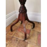 20th. C. mahogany revolving two tier drinks' table raised on turned column and four outswept feet,