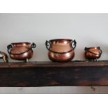 Set of seven graduated beaten copper and metal pots with brass feet { 19cm H X 27cm Dia - 8cm H X