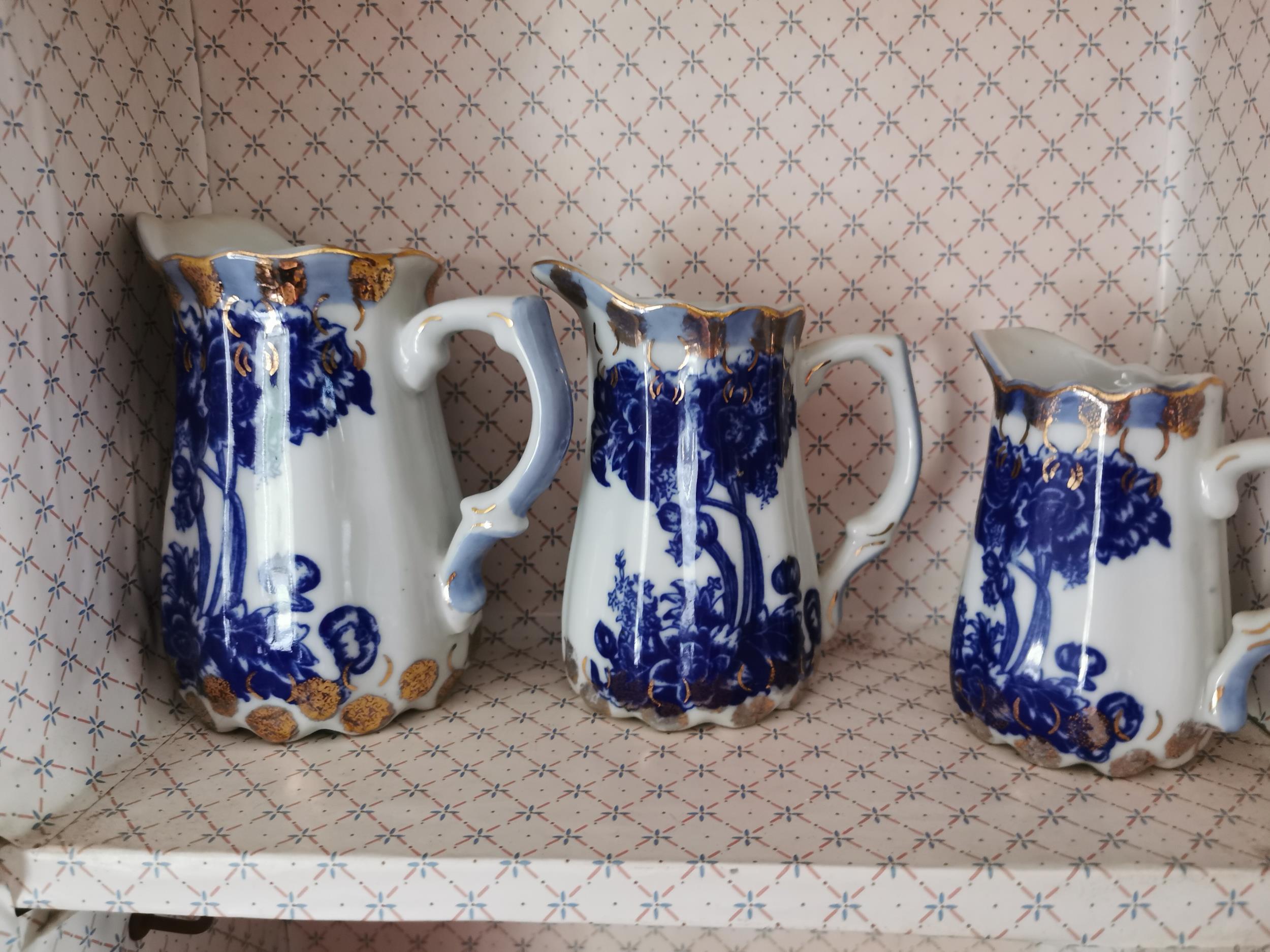 Set of five graduated blue and white ceramic jugs { 21cm H X 14cm Dia - 11cm H X 9cm Dia }.
