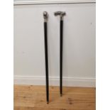 Two silver plate and ebonised walking sticks. {95 cm H}.