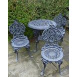 Four piece cast patio suite with circular table and three matching chairs.