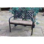 Cast aluminium two seater garden bench with cushion . {90 cm H x 100 cm W X 44 cm D}.