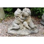 Stone figural group of kissing Cherubs. {50 cm H x 66 cm W x 35 cm D}.