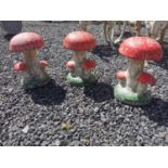 Set of three painted composition toad stools {33 cm H x 22 cm Dia.}.