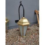 Two brass and glass wall hanging lanterns with metal brackets. {150 cm H x 107 cm W x 65 cm D}