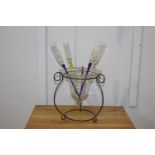Set of four champagne flutes in glass bowl on stand.