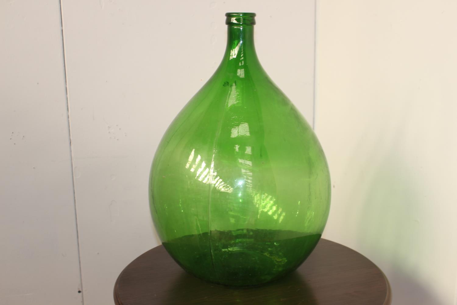 Green glass wine bottle {66 cm H x 42 cm Dia.}.