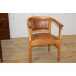 Wooden and tan leather upholstered armchair raised on tapered legs {75 cm H x 54 cm W x 46 cm D}.