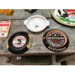 Two tin plate Guinness ashtrays and Draught Guinness ceramic ashtray {15 cm Dia.}.