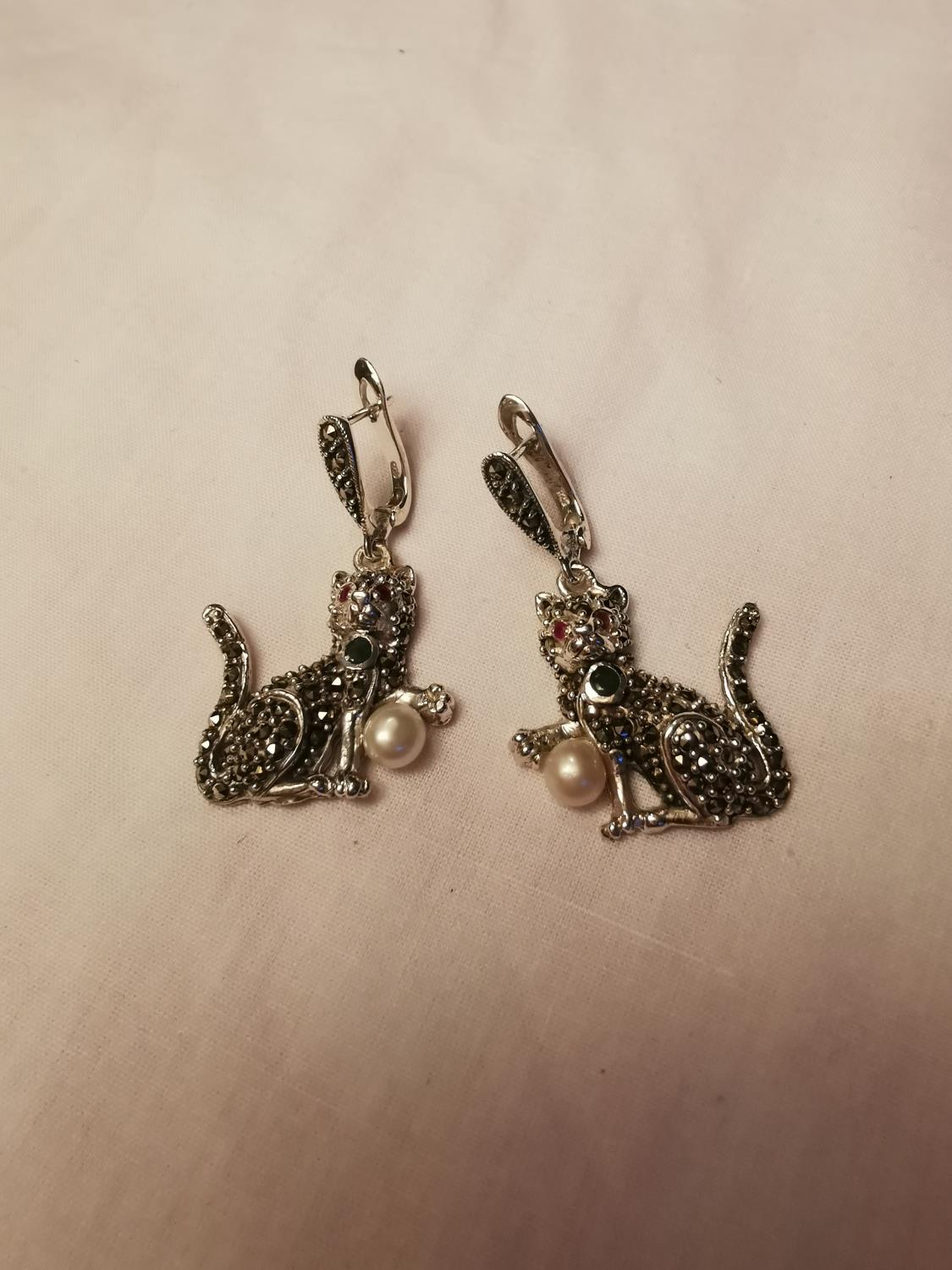 Pair of silver and marcasite earrings in the form of cats with ruby eyes