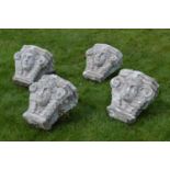 Set of four carved stone capitals {50 cm H x 42 cm W}.