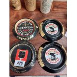 Four tinplate Guinness ashtrays. {15 cm Dia}.