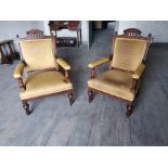 Pair of Edwardian upholstered mahogany open armchairs raised on turned legs { 97cm H X 65cm W X 64cm