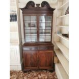 Georgian mahogany bookcase, the swan necked pediment above two astragal glazed doors over two