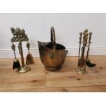 Brass coal helmet { 48cm H X 31cm W X 37cm D } and two sets of brass fire irons { 45cm H }.