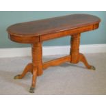 Walnut oval coffee table raised on turned supports and four out swept legs in the Regency style {