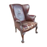Edwardian leather upholstered wing backed armchair raised on carved mahogany cabriole legs { 104cm H
