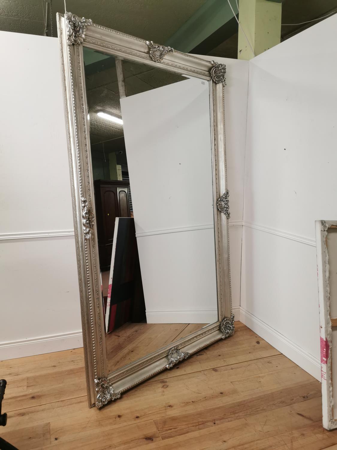 Decorative wall mirror mounted in a silver gilt frame { 244cm H X 146cm W }.