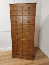 Early 20th. C. painted pine bank of twenty five short drawers with original handles, raised on