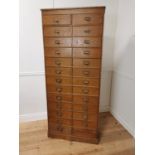 Early 20th. C. painted pine bank of twenty five short drawers with original handles, raised on