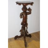 Carved mahogany jardiniere stand, the column in the form of a boy holding fruit raised on three