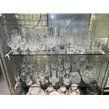 TWO SHELVES OF CUT GLASSWARE INCLUDING TUMBLERS, BRANDY GLASSES, VASES,