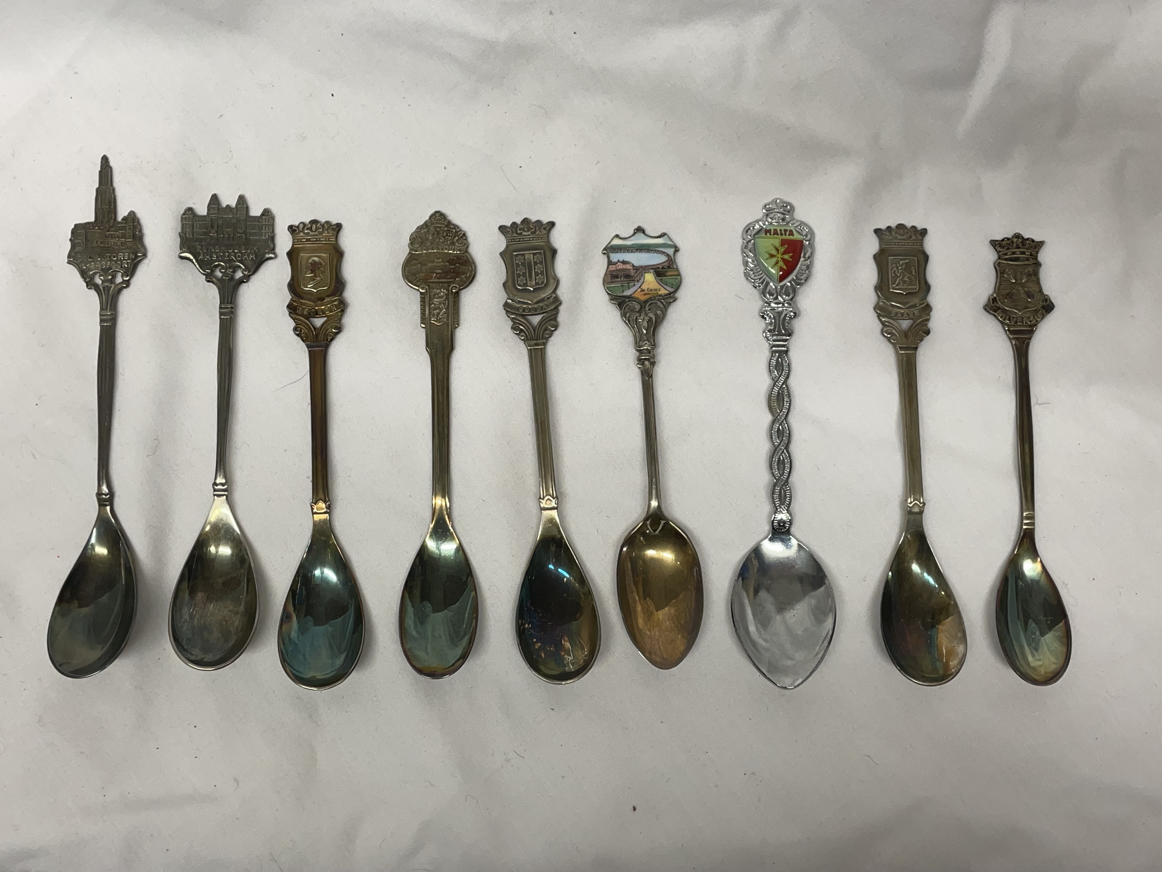 SMALL BAG OF SILVER AND WHITE METAL SOUVENIR TEASPOONS