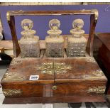 LATE VICTORIAN OAK AND METAL STRAP WORK THREE BOTTLE TANTALUS,