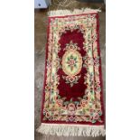 CHINESE RED GROUND WASH WOOLEN RUG AND A SHEEPSKIN RUG