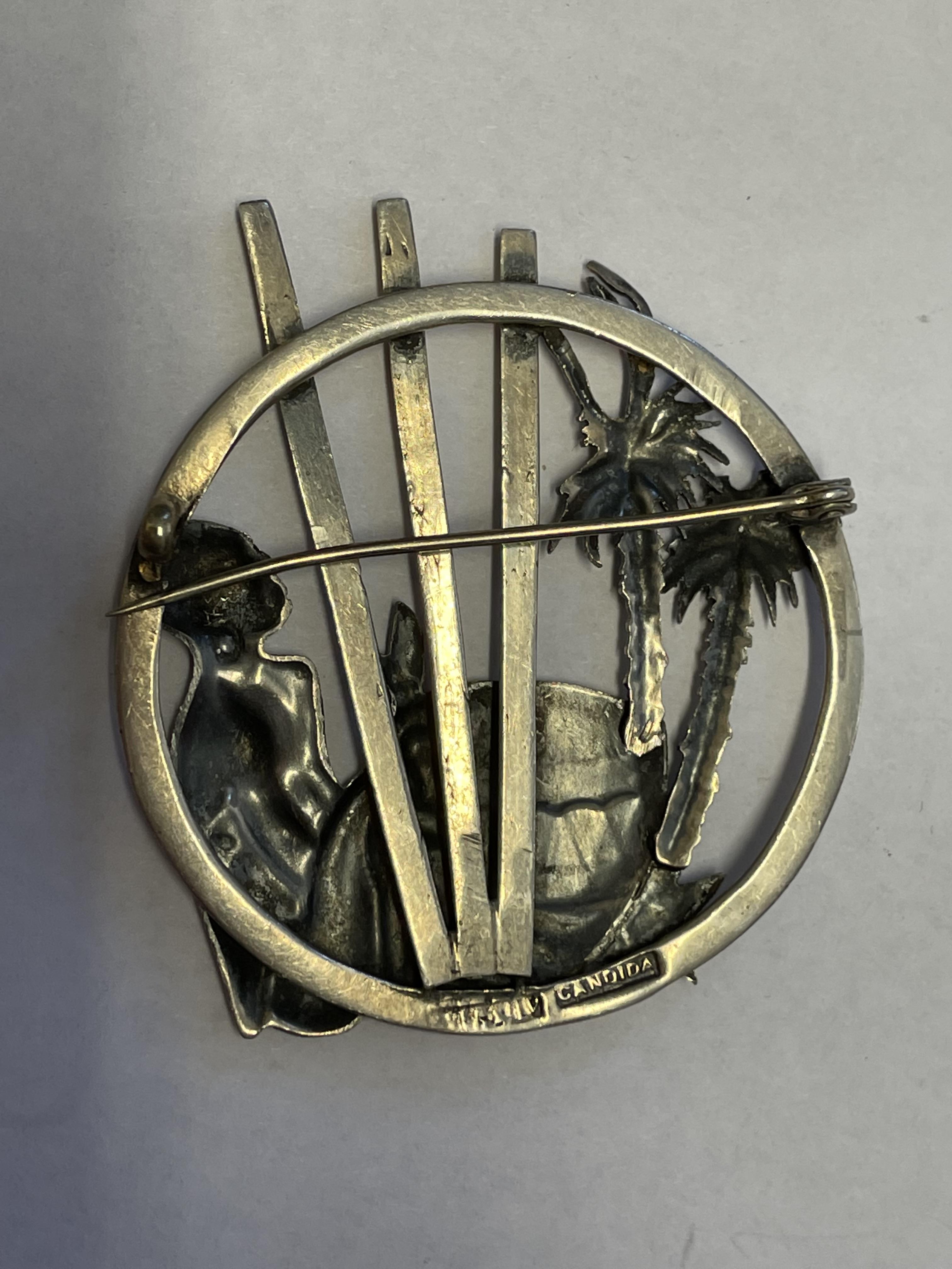 WHITE METAL BROOCH DEPICTING A MAN PLAYING A DRUM AMONGST PALM TREES - Image 3 of 4