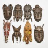 A Group Six Decorative African Masks, together with two Papua New Guinea-style papier maché and burl