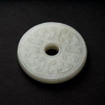 A White Jade Archaistic Bi Disc, Qing Dynasty, 19th Century, 清 十九世纪 白玉雕勾云谷纹璧, diameter 2.3 in — 5.9