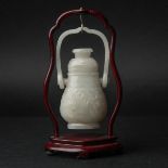 A White Jade 'Taotie' Hanging Vase, Ming Dynasty or Earlier, 明或更早 白玉雕饕餮纹提梁壶, with stand height 6.9 i