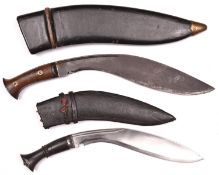 A kukri, with riveted wood grips, the blade stamped "J.N.B.43", in its black leather covered