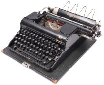A 1940s Olympia portable typewriter made for the German market, with lid and carrying handle.