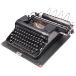 A 1940s Olympia portable typewriter made for the German market, with lid and carrying handle.