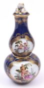 A Dresden porcelain double gourd lidded vase on dark blue base with scenes of courting couples. VGC.