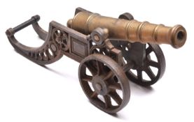 A decorative cannon, brass barrel 11", on its 2 wheeled iron carriage. GC £40-60