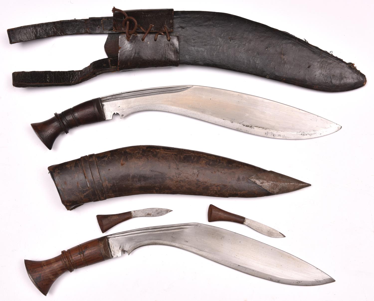 A kukri, with plain wood hilt, in its leather covered sheath with belt loops; and another, with