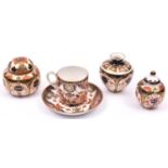 4x porcelain items of Royal Crown Derby. A coffee cup and saucer, a vase and 2x lidded pots with