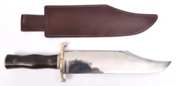 A large Bowie knife, broad flat clipped back blade 11", the hilt having pale brass mounts comprising