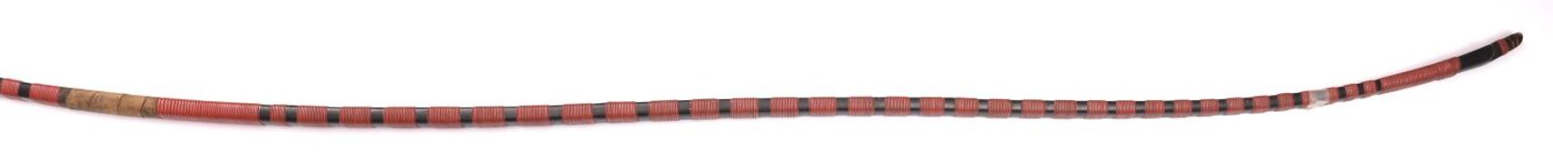A Japanese bow, Yumi, 86? overall (7?2?), covered with black lacquer with bands of red lacquer
