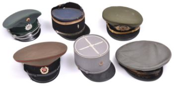A US Navy officers peaked cap, 3 other peaked caps: Russian, GDR, South American and 2 kepis. GC (6)