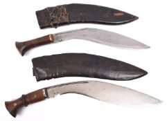A kukri, the blade spuriously dated 1915, with rivetted wood grips, in its leather covered sheath;